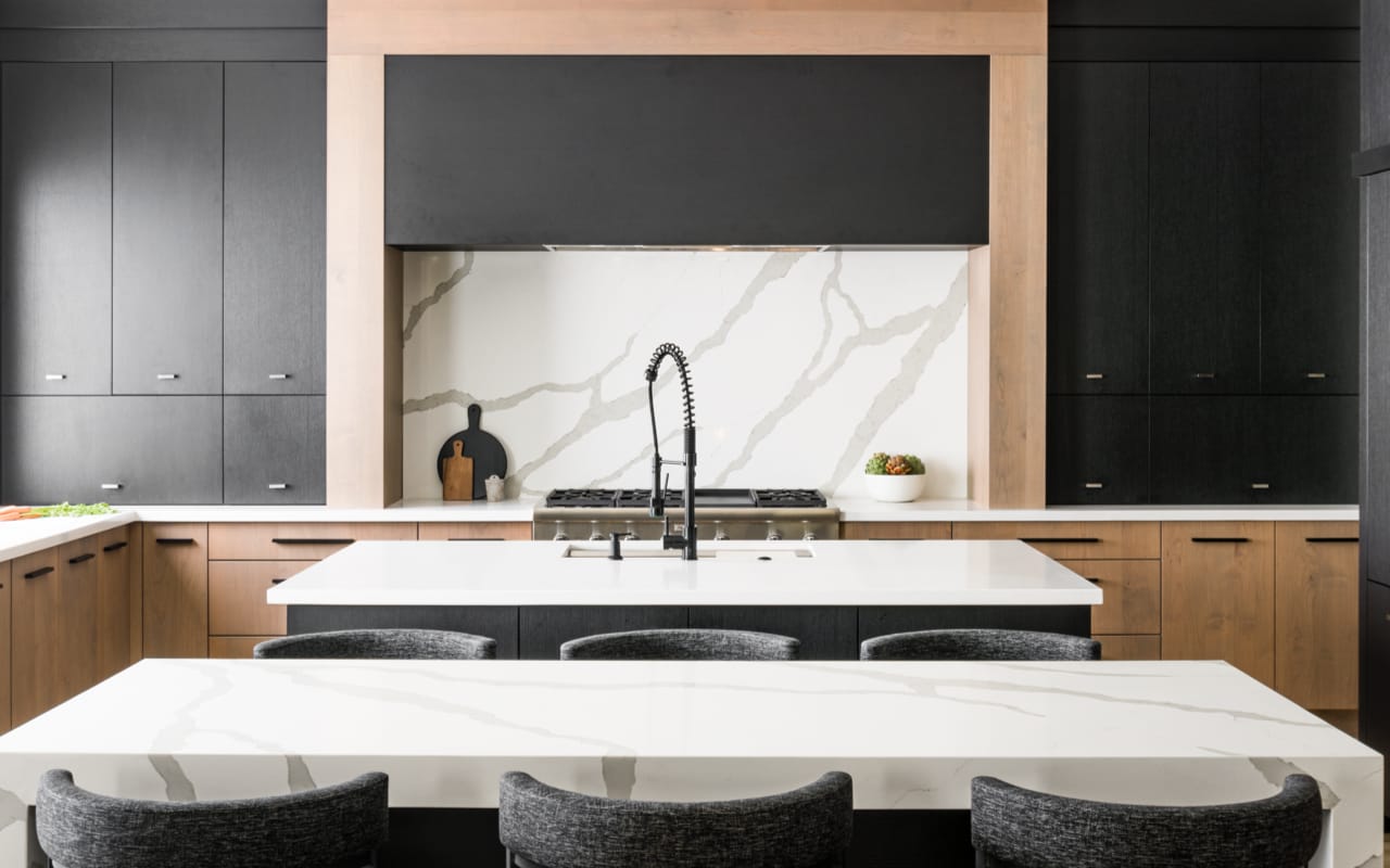 Close-up of a kitchen range with light maple and black cabinetry.